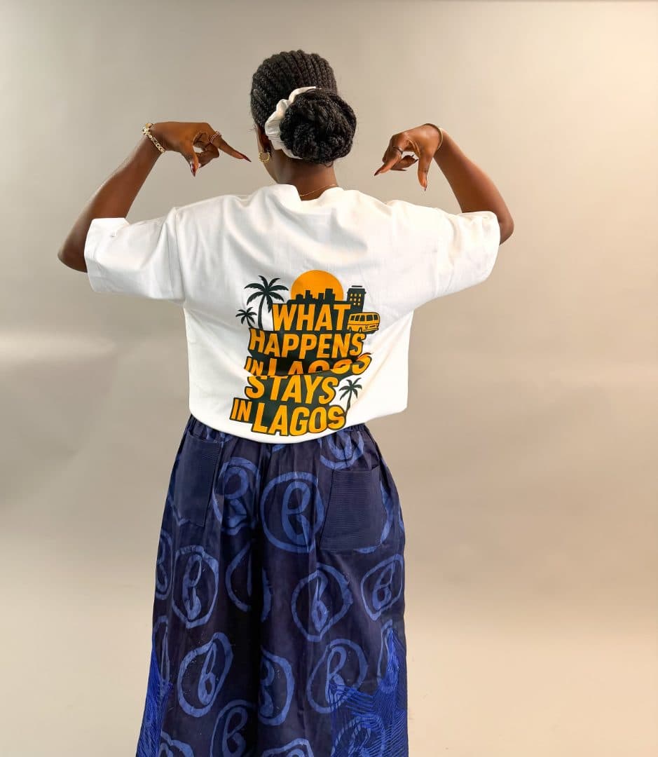 Model wearing the What Happens in Lagos Tee in white