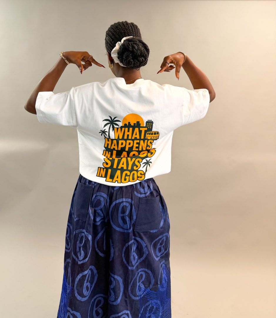 Model wearing the What Happens in Lagos Tee in white